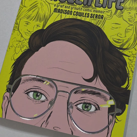 Preview of the shiny silver foil cover details on the book. The title, glasses, and highlights in the eyes are shiny.